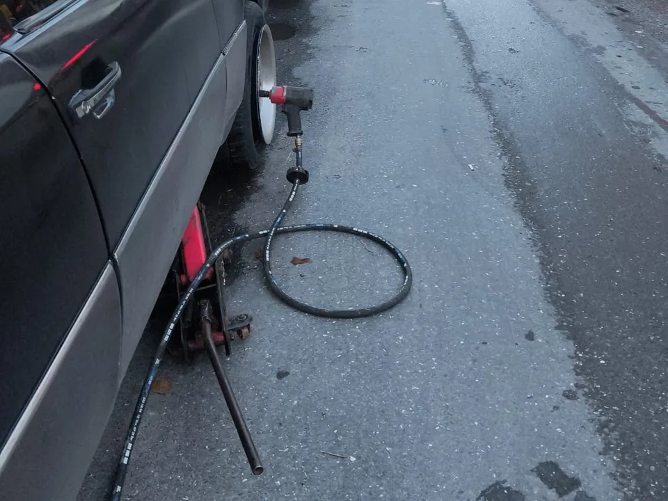 Cadde kenarında kriko ve havalı tabanca ile lastik değişimi — Çıkma Lastik Almadan Önce Bilmeniz Gerekenler için örnek çalışma fotoğrafı
