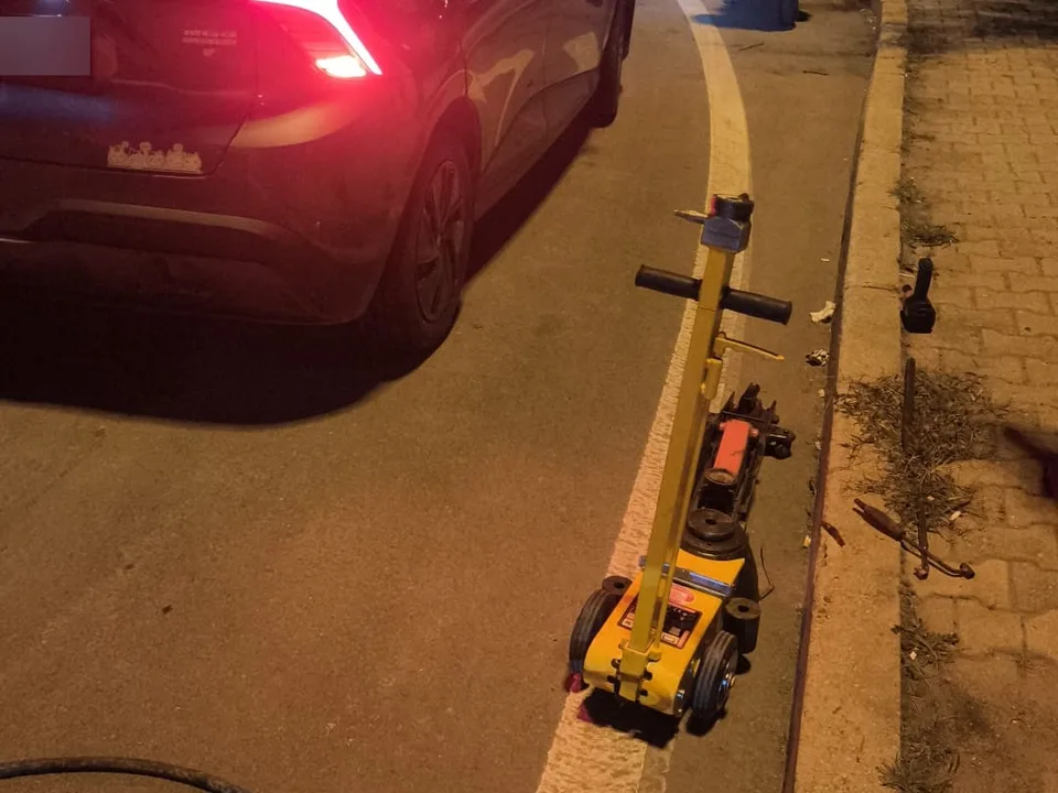 Gece yol kenarında sarı hidrolik kriko ile lastik hizmeti — Bahçelievler için örnek çalışma fotoğrafı