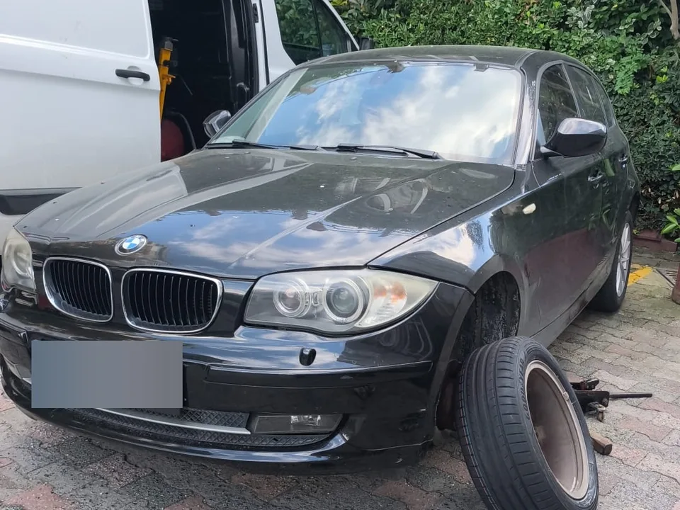 Tekerleği sökülmüş araç, yanında servis aracı ve havalı tabanca — Lastik Yol Yardım için örnek çalışma fotoğrafı