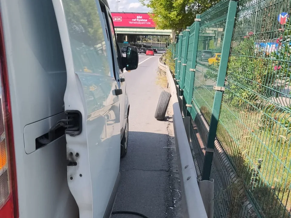 Yol kenarında bariyer ve çit önünde kapısı açık servis aracı — Şişli için örnek çalışma fotoğrafı