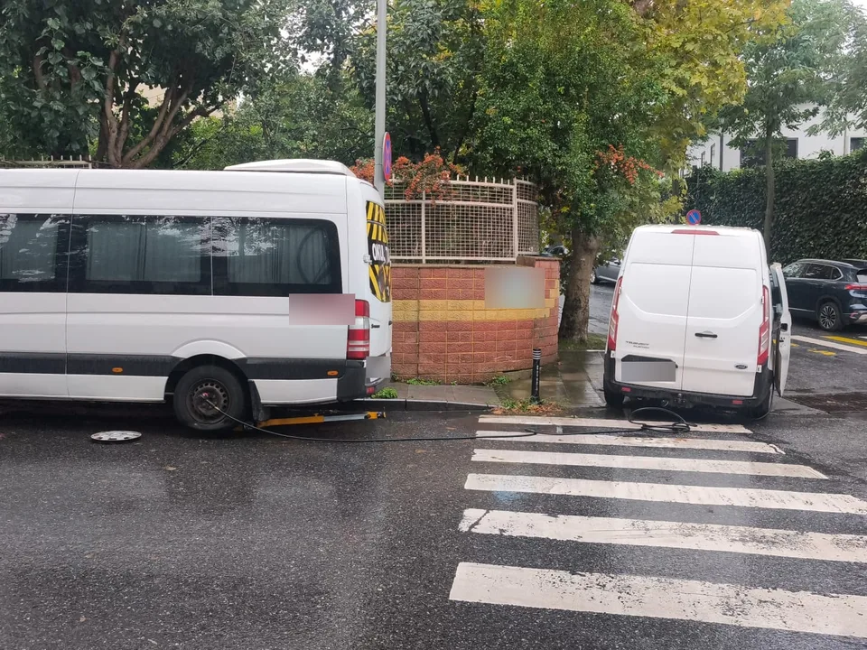 Yağışlı havada yaya geçidi yanında park halindeki minibüs ve servis aracı — Kadıköy için örnek çalışma fotoğrafı